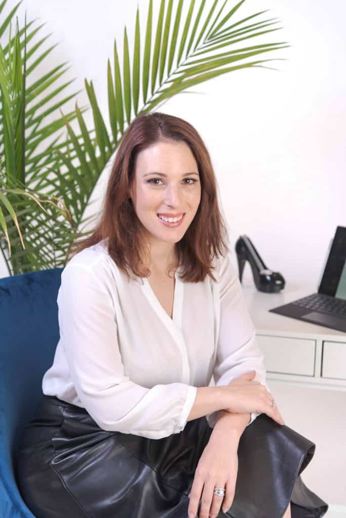 Annmarie Gustafson, Web Designer and Email Marketing Expert, sits at her computer.